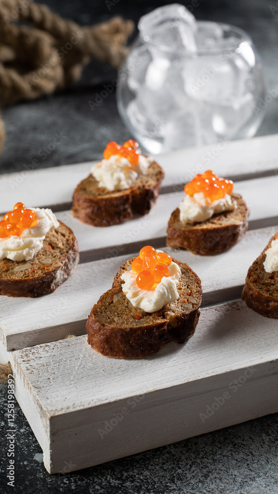 Small toasts with red salmon caviar on black bread Small toasts with red salmon caviar on black bread