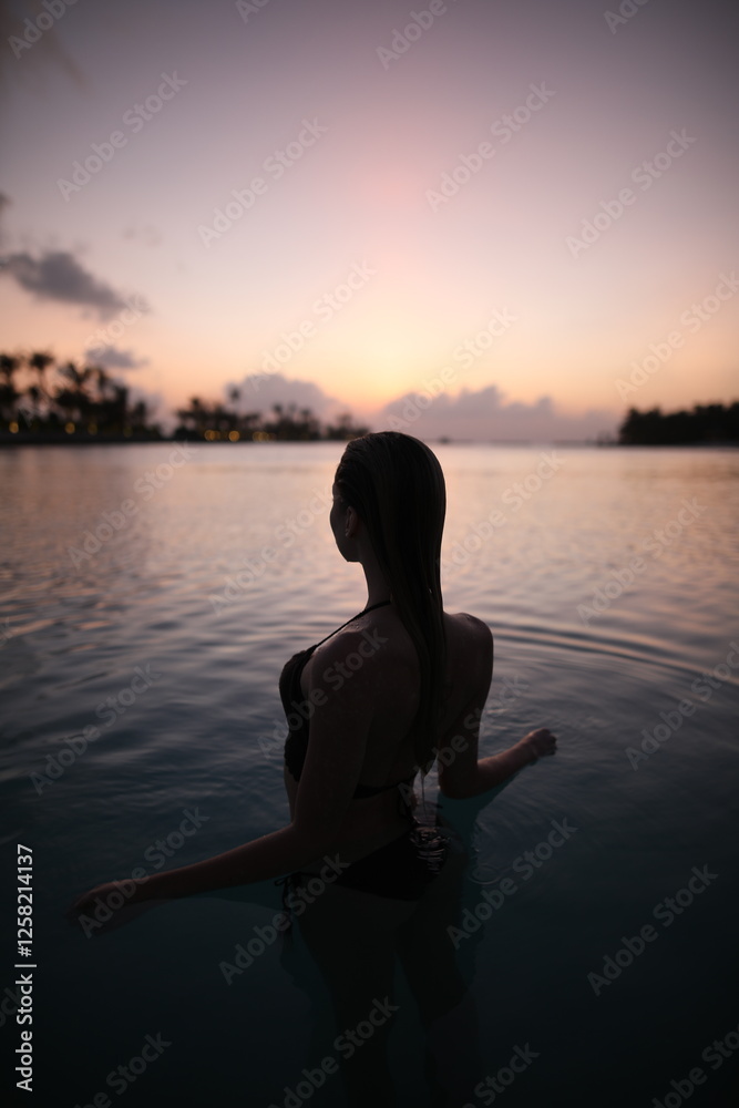 Fototapeta premium Woman in ocean during sunset