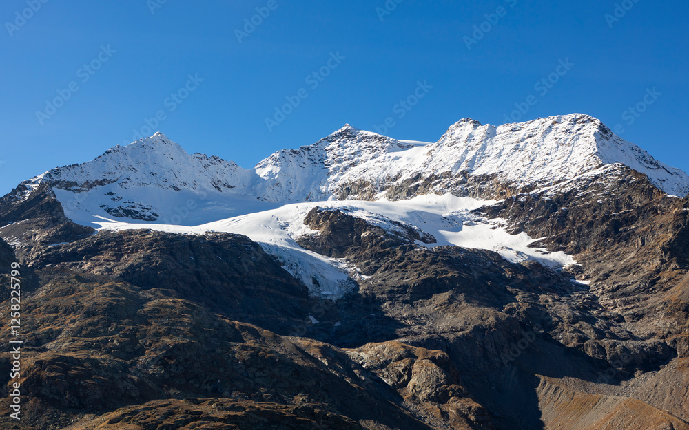 Piz Cambrena with snow capped summit and blue sky. Impressive mountain range at Bernina mountain pass. Piz Cambrena with snow capped summit and blue sky. Impressive mountain range at Bernina mountain pass.