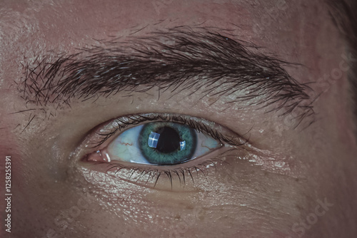 Close-up of a man's green eye. Toned