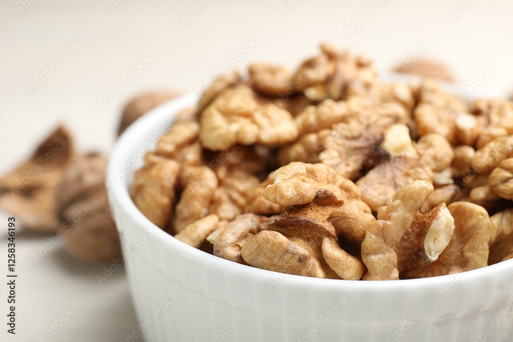 Peeled walnuts in bowl on light table, closeup Peeled walnuts in bowl on light table, closeup