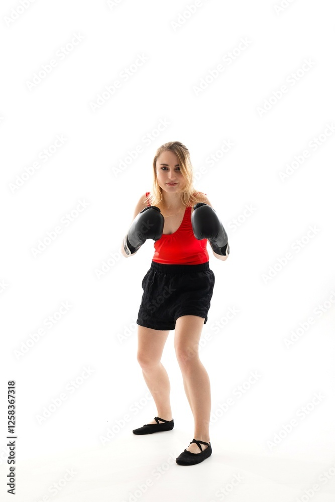 Female boxer training in red tank top and black shorts preparing for a match with boxing gloves on a white background Female boxer training in red tank top and black shorts preparing for a match with boxing gloves on a white background