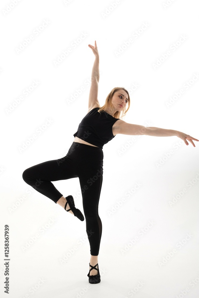 Female dancer performing an elegant pose in a studio with bright white background during a dance rehearsal session Female dancer performing an elegant pose in a studio with bright white background during a dance rehearsal session