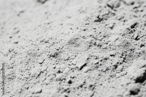 Close-up of volcanic ash texture, soft gray powder with tiny porous rock fragments.