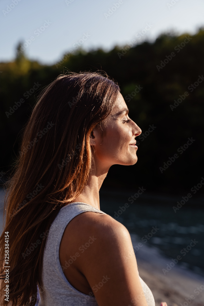 Portrait of young woman with long hair enjoying sun with closed eyes Portrait of young woman with long hair enjoying sun with closed eyes