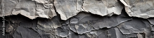 A close-up shot of a worn-out rock wall with peeling paint, great for use in industrial or urban themed designs photo