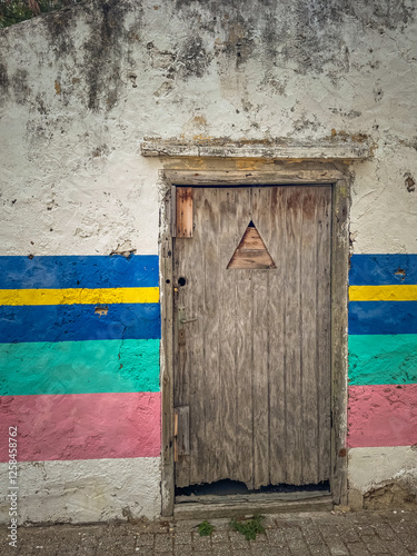 Old wooden door on a disheveled plaster wall