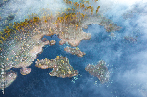 Obraz na płótnie Drone panorama on tiny isles in lake in colorful sunrise colors. Top down view on swamp with isle. Sustainable ecosystem of wetlands. w salonie