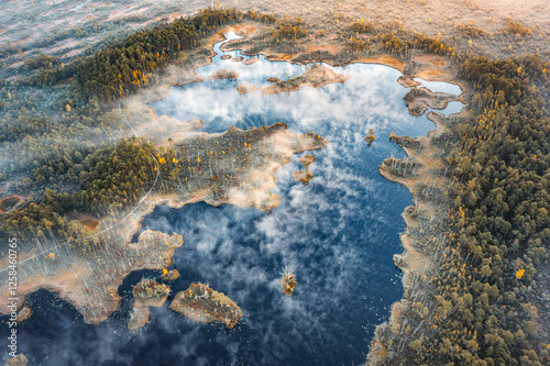 Obraz na płótnie Drone panorama on tiny isles in lake in colorful sunrise colors. Top down view on swamp with isle. Sustainable ecosystem of wetlands. w salonie