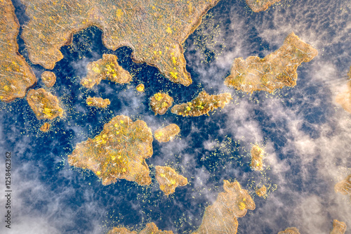 Obraz na płótnie Drone panorama on tiny isles in lake in colorful sunrise colors. Top down view on swamp with isle. Sustainable ecosystem of wetlands. w salonie