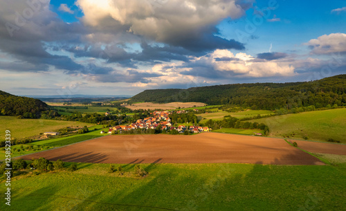 Obraz na płótnie Vibrant German Village Nestled in a Valley Surrounded by Lush Greenery and Picturesque Mountains on a Bright Sunny Day w salonie