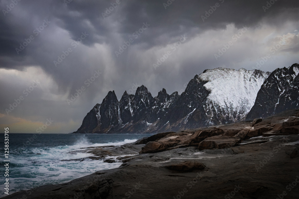 Fototapeta premium Landscape with breaking waves in front of the Devils Teeth on the Island of Senja in Northern Norway