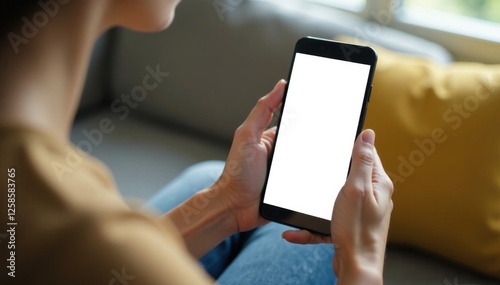 Woman sits on couch with blank mobile phone held in her hand  device  sitting  modern