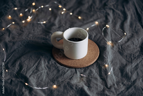 Cup of coffee on a bed with a warm blanket. Winter holiday season, cozy home. photo