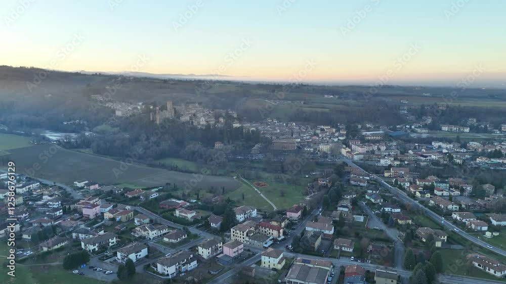 Castell'Arquato fortress overlooking the Arda Valley and nearby houses, capturing the serene beauty of a peaceful sunset. A stunning aerial view reveals the charm of this medieval village Castell'Arquato fortress overlooking the Arda Valley and nearby houses, capturing the serene beauty of a peaceful sunset. A stunning aerial view reveals the charm of this medieval village