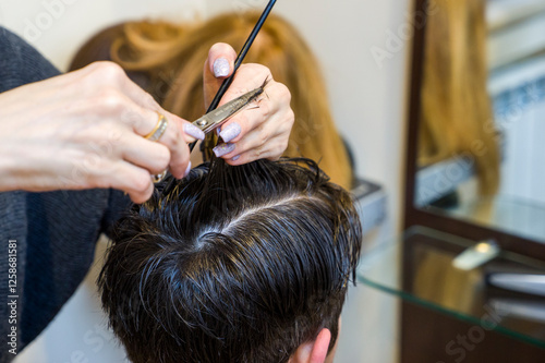 men's hairstyling and haircutting with hair clipper in a barber shop or hair salon,close up