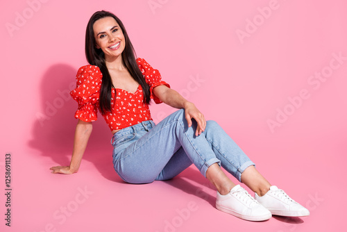 Full size photo of pretty young woman sit floor wear top isolated on pink color background