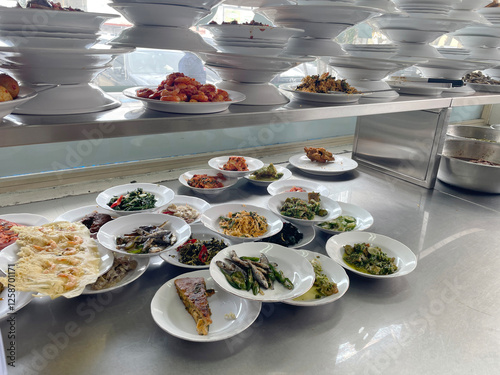 Indonesian padang restaurant menu, A vibrant array of dishes is presented on white plates, showcasing an inviting selection of food in a lively buffet environment