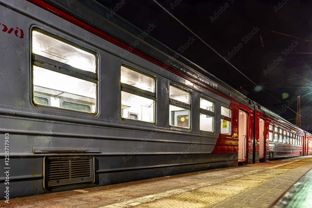 Obraz premium Suburban train with open doors on the platform in the evening. Dmitrov, Moscow region, Russia