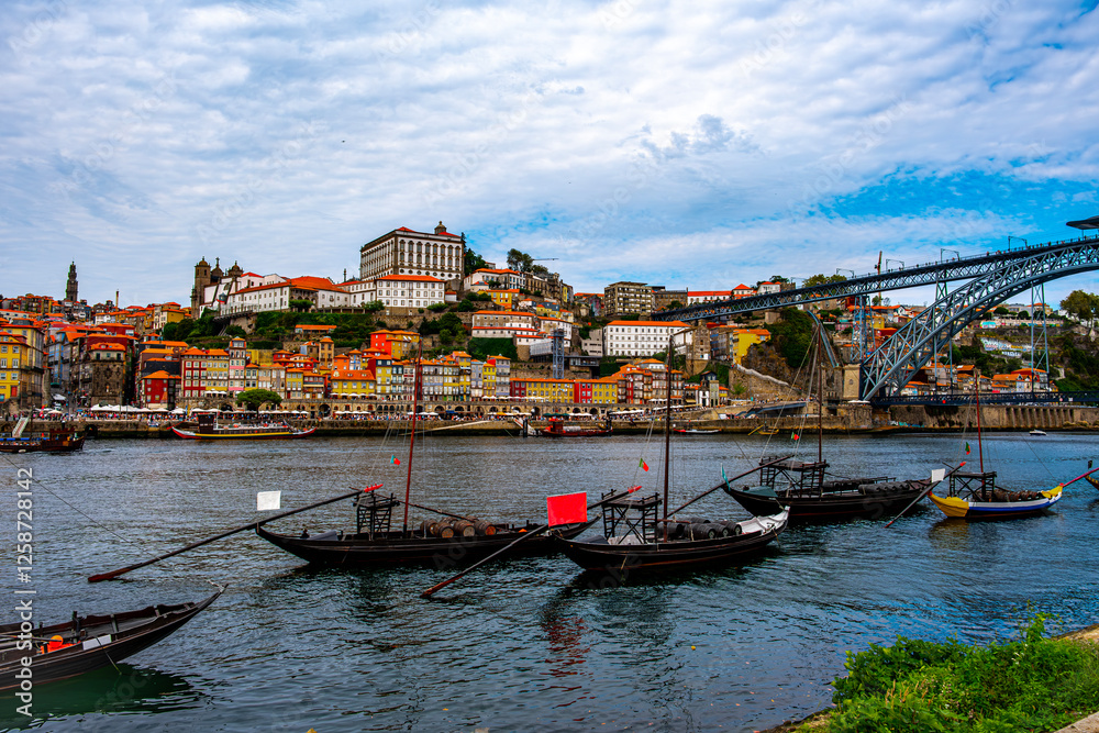 Obraz premium A shot of the cozy town in the distance and the stern ships in the foreground, with the stunning large bridge on the right