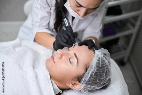 Professional eyebrow permanent makeup session in spa setting