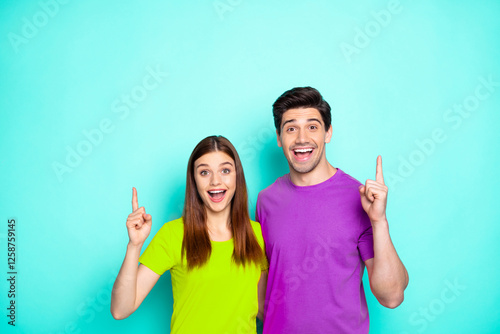 Portrait of his he her she nice attractive charming friendly cheerful glad couple hugging pointing up ad advert new tips feedback isolated over bright vivid shine vibrant green turquoise background photo