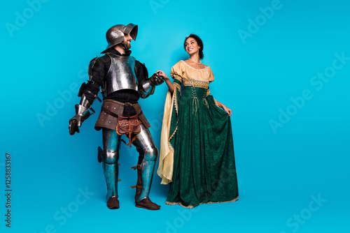 A man as a knight and a woman in princess attire portrayed with a vibrant pink background showcasing historic and playful costumes. photo