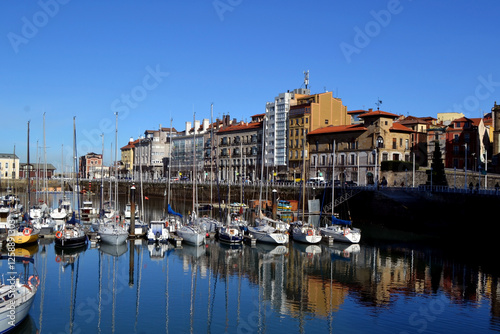 Charming Gijon coastal scene with boats and architecture by the Atlantic ocean. Gijon, Asturias. Bay of Biscay. Cantabrian sea photo