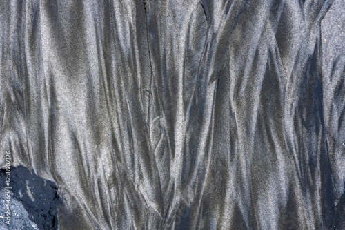 Black and white sand of Parusnaya Bay, Iturup Island. Black is titanium magnetite sand, it can be attracted to a magnet. White - sand of volcanic pumice photo