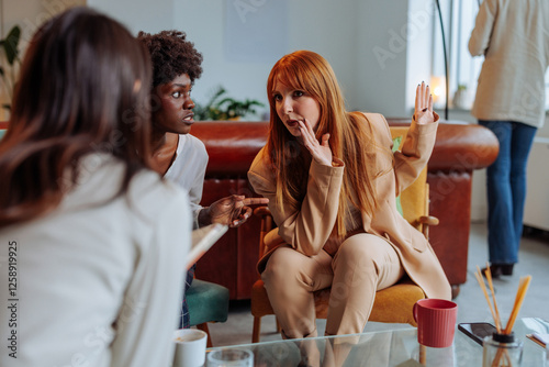 Businesswomen gossiping about a colleague in cafeteria
