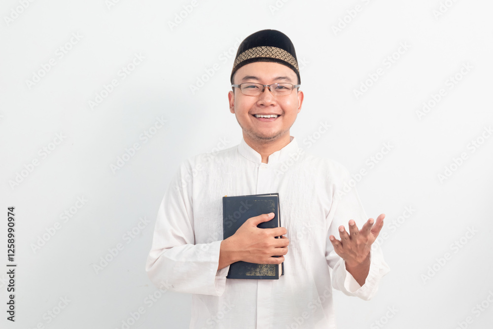 Asian Muslim man wearing white clothes welcoming and holding quran during Ramadan Eid Al Fitr and eid adha days celebration isolated white background. Islamic celebration concept.. Asian Muslim man wearing white clothes welcoming and holding quran during Ramadan Eid Al Fitr and eid adha days celebration isolated white background. Islamic celebration concept..