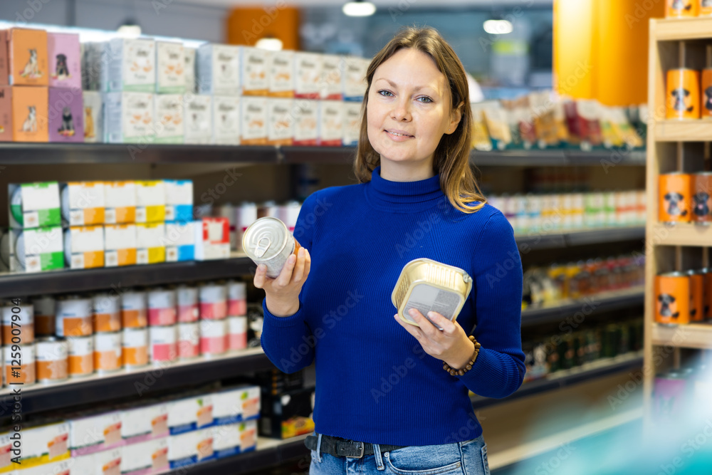 Female customer picking out canned pet food in pet store Female customer picking out canned pet food in pet store