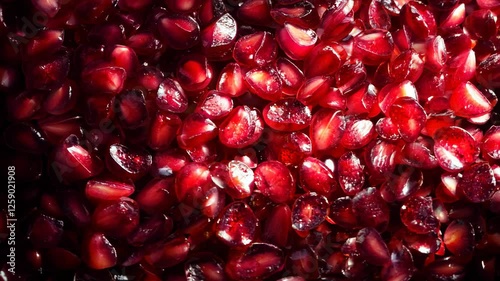 A spread of glistening pomegranate seeds completely covering the frame, their deep red tones glowing under soft light.