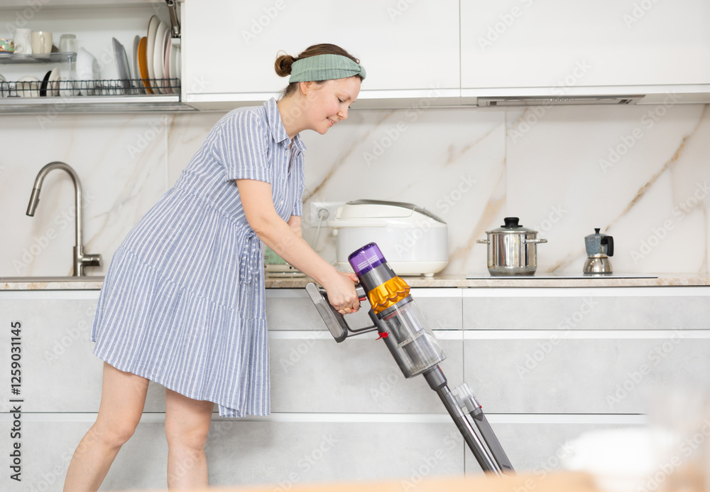 Housewife using a vacuum cleaner removes dust in the room Housewife using a vacuum cleaner removes dust in the room