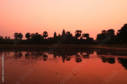 The temple of Angkor Wat in front of a pink sky before sunrise, reflecting on the water, pond, lake, Siem Reap, Cambodia photo