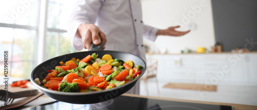 Male chef frying vegetables...