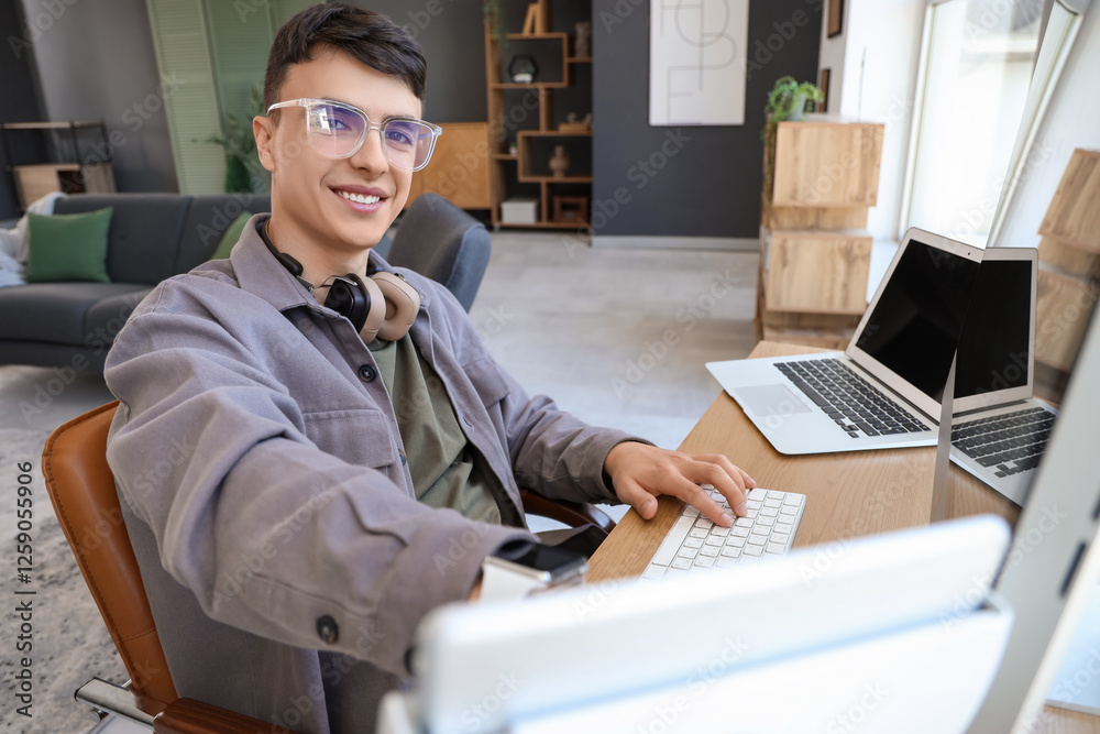 Fotografie Young man using computer at desk in office