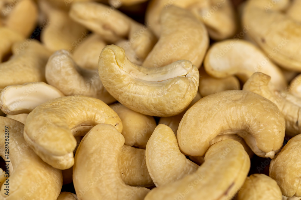 large cashew nuts are scattered on a larch board large cashew nuts are scattered on a larch board