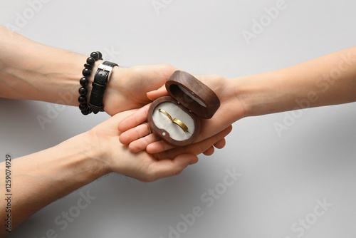Couple holding wedding ring...