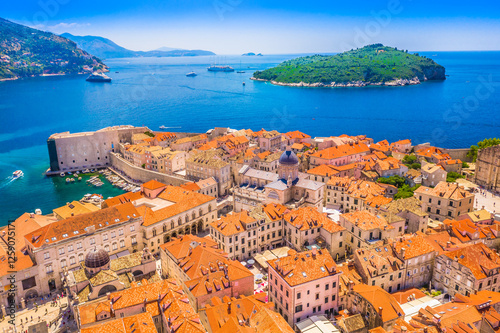 A breathtaking view over Dubrovnik’s historic city walls and terracotta rooftops, with the stunning Adriatic Sea and the lush green island of Lokrum creating a perfect Mediterranean scene.
