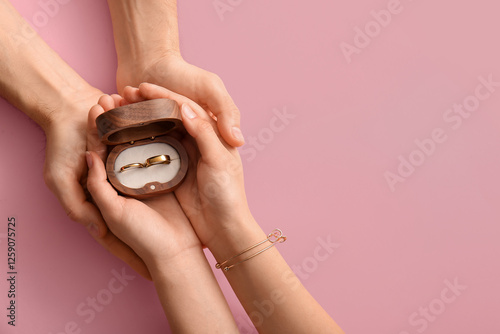 Couple holding wedding ring...