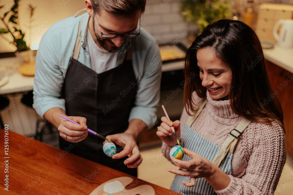 Couple enjoying creative easter egg painting together Couple enjoying creative easter egg painting together