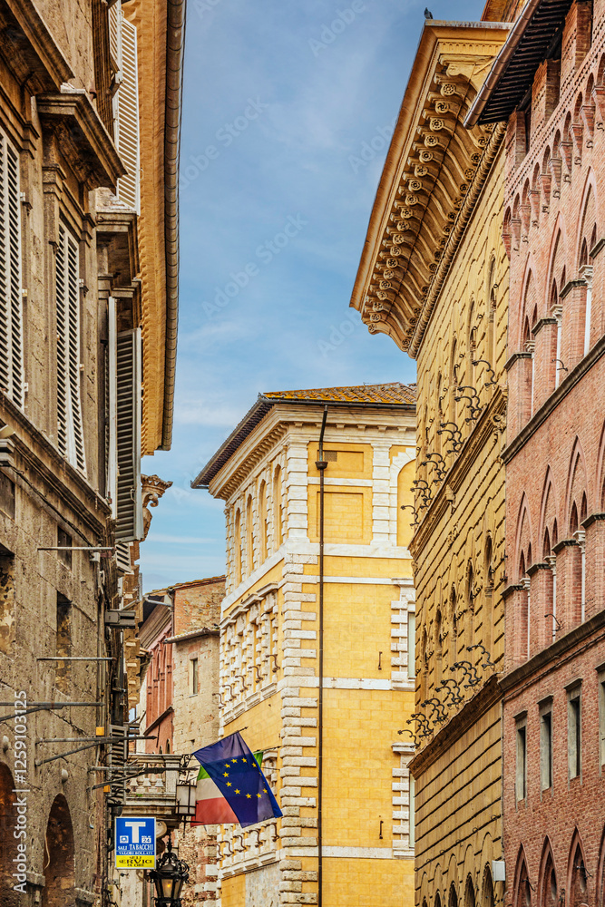Obraz premium Facade of old buildings in the historical center of Siena, the UNESCO World Heritage Centre, unchanged for 13-14 centuries, with its medieval streets looked like in the early Middle Ages. Italy, 2019