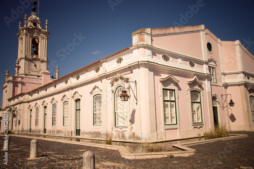 Historic pink building with bell tower in Sintra, Portugal, under clear sky.