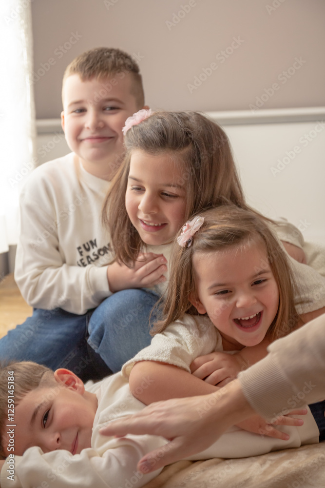 Fototapeta premium four children, sisters and brothers playing with each other, showing family love