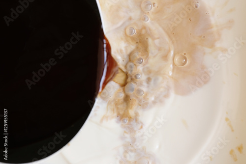 Pouring black coffee into milk for smoother and creamy flavour photo