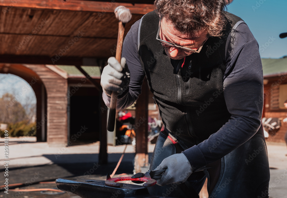 Blacksmith forging horseshoe on anvil Blacksmith forging horseshoe on anvil