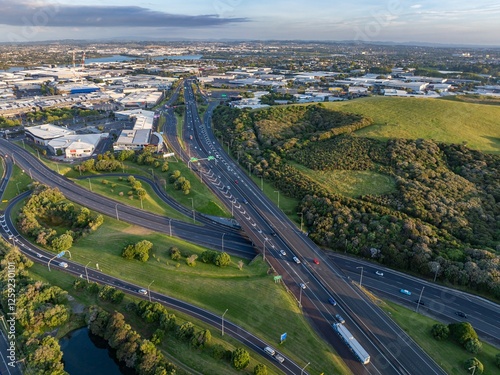 High-angle view of a highway intersection, cars and trucks traversing the road, and surrounding urban landscape. MT WELLINGTON, AUCKLAND, NZ photo