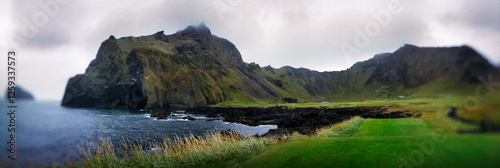 Panoramic green landscape along the coastline, Heimaey island, Westman Islands, Iceland.