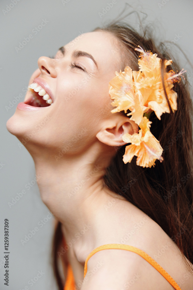 Joyful young woman smiling with orange flowers in her hair, set against a soft gray background, perfect for summer fashion concepts and beauty promotions. Joyful young woman smiling with orange flowers in her hair, set against a soft gray background, perfect for summer fashion concepts and beauty promotions.